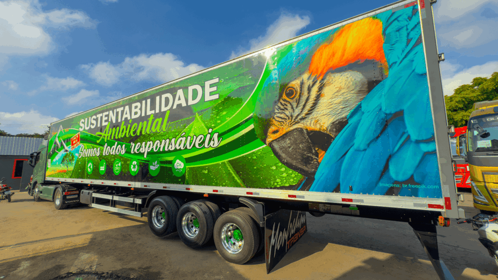 Trailer da Monfredini Transportes com design de arara e ícones ecológicos promovendo sustentabilidade ambiental